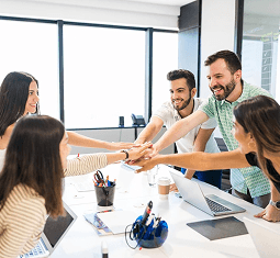 Colleagues celebrating with a high five at a meeting table